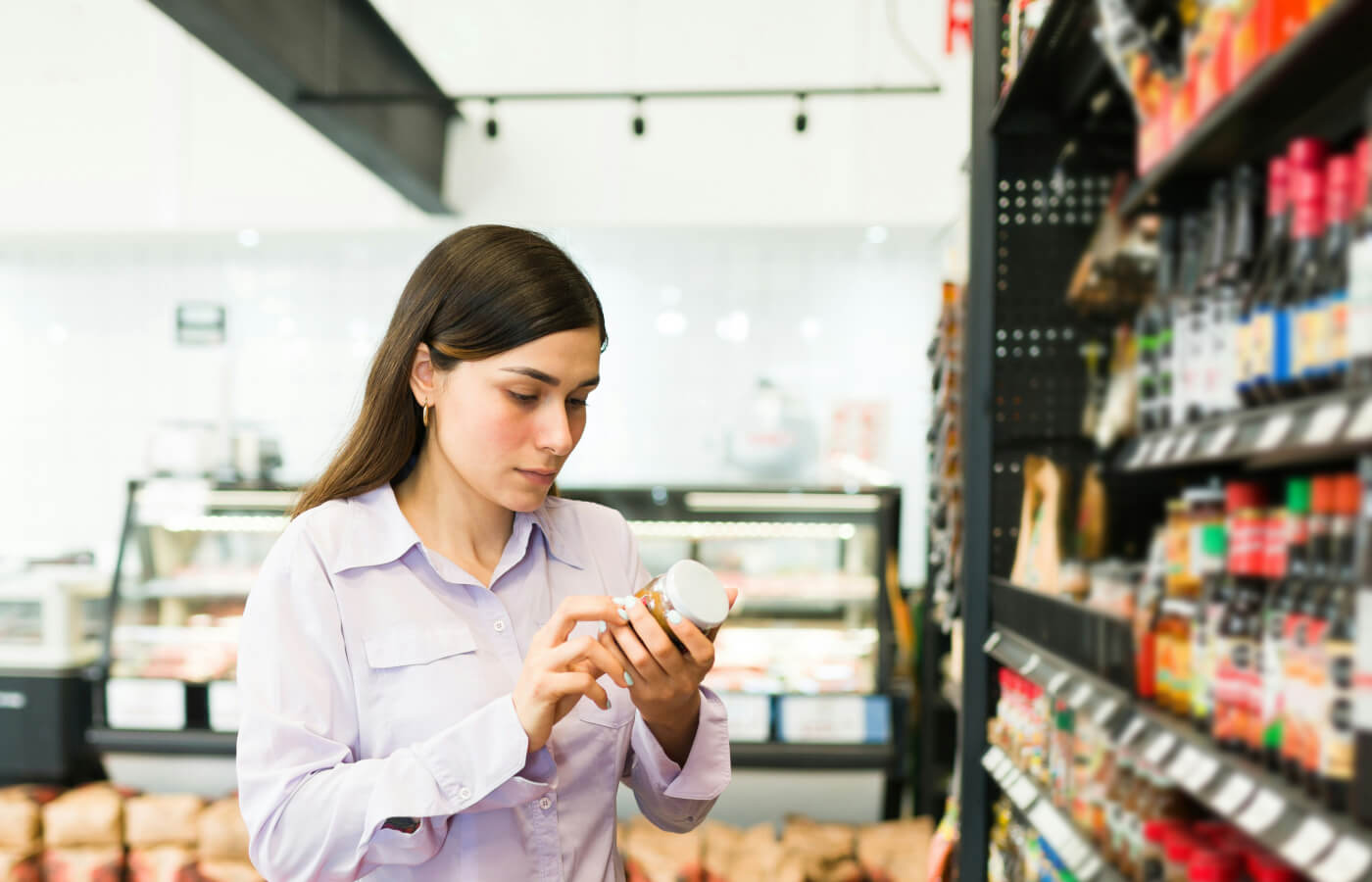 woman looking at products ingredients at grocery store