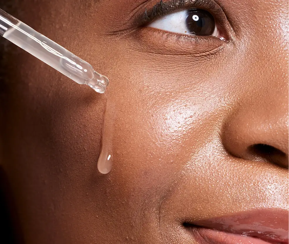 Woman applying serum to face