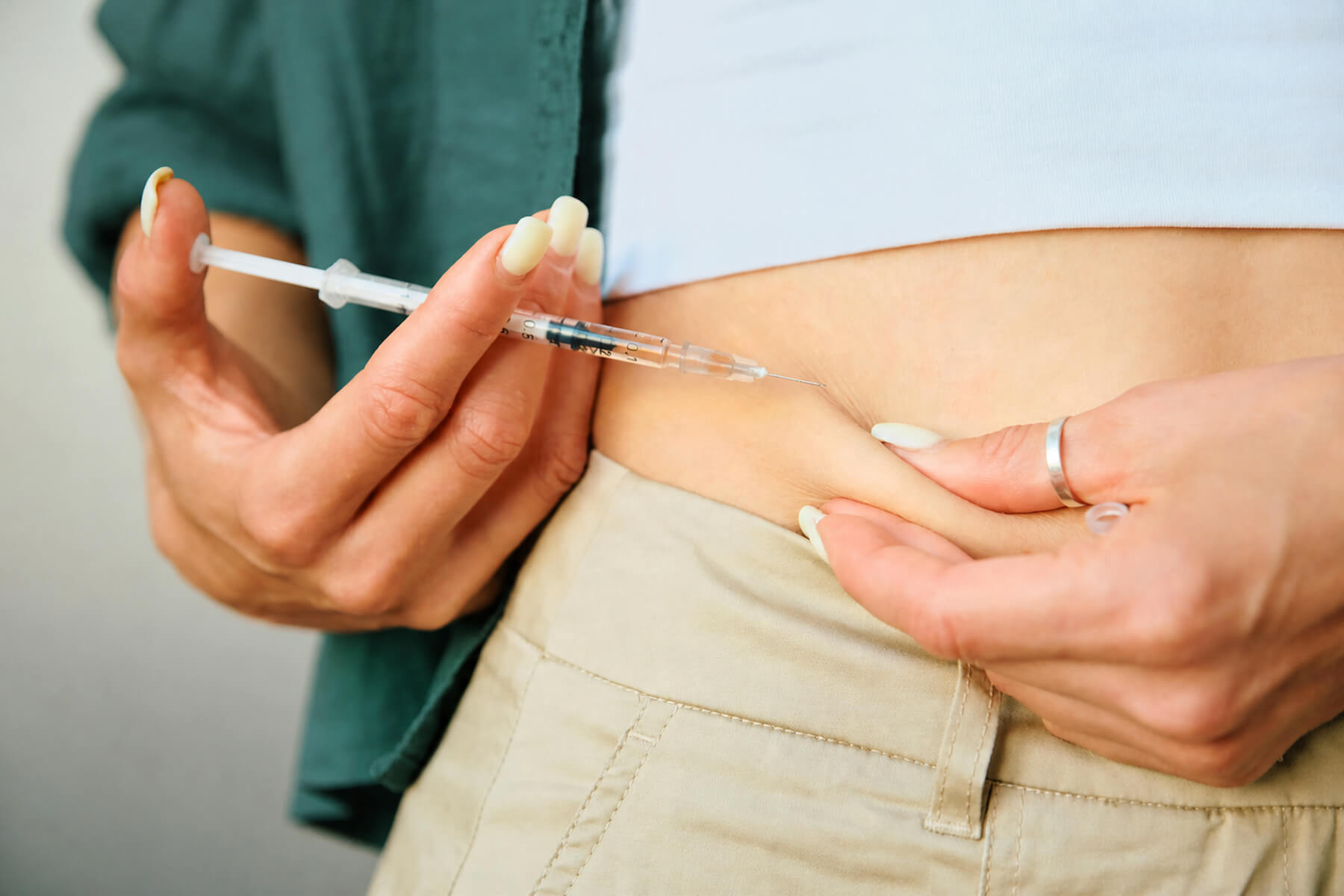 Person injecting serum into their stomach